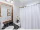 Charming bathroom features granite countertop, decorative mirror, and white shower curtain at 200 Long Needle Ct, Sugar Hill, GA 30518