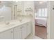 Bright bathroom with double sinks, a large mirror, and an attached bedroom at 200 Long Needle Ct, Sugar Hill, GA 30518