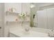 A bright bathroom featuring a double vanity and decorative shelves at 200 Long Needle Ct, Sugar Hill, GA 30518