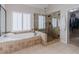 Bright bathroom featuring a soaking tub, walk-in shower, and open doorway to the closet at 200 Long Needle Ct, Sugar Hill, GA 30518