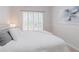 Bright bedroom featuring plantation shutters and a modern accent wall hanging at 200 Long Needle Ct, Sugar Hill, GA 30518