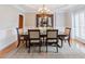 Formal dining room showcasing a classic chandelier, elegant dining set, and decorative wainscoting details at 200 Long Needle Ct, Sugar Hill, GA 30518