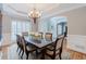 An elegant dining room that features a formal dining set, natural lighting from shuttered windows, and a china cabinet at 200 Long Needle Ct, Sugar Hill, GA 30518