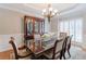 Sophisticated dining room with a dark wood table, a chandelier, and a hutch for storing glassware at 200 Long Needle Ct, Sugar Hill, GA 30518