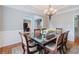 Elegant dining room with a chandelier, beautiful table setting, and decorative wainscoting at 200 Long Needle Ct, Sugar Hill, GA 30518