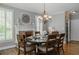Formal dining room boasts an elegant chandelier, fireplace, and large windows with shutters at 200 Long Needle Ct, Sugar Hill, GA 30518