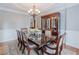 A dining room featuring a dark wood table, china cabinet, and an elegant chandelier for a touch of sophistication at 200 Long Needle Ct, Sugar Hill, GA 30518