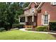 Brick home exterior with a covered front porch and manicured landscaping at 200 Long Needle Ct, Sugar Hill, GA 30518