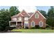 Beautiful two-story brick home with a well-maintained lawn, mature trees, and classic shutters at 200 Long Needle Ct, Sugar Hill, GA 30518