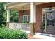 Inviting brick home with a charming covered front porch and manicured landscaping at 200 Long Needle Ct, Sugar Hill, GA 30518