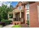 Close-up of the brick facade and cozy porch, enhanced by manicured landscaping at 200 Long Needle Ct, Sugar Hill, GA 30518