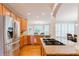 Well-lit kitchen with stainless steel refrigerator, granite countertops, and connection to breakfast area at 200 Long Needle Ct, Sugar Hill, GA 30518