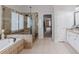 Luxury main bathroom with tub and tiled shower, offering a spa-like experience at 200 Long Needle Ct, Sugar Hill, GA 30518