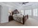Spacious main bedroom with tray ceiling and large bed, bathed in natural light from shuttered windows at 200 Long Needle Ct, Sugar Hill, GA 30518
