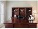 This is a bright office showcasing a traditional desk and hutch, carpeted floors, and natural lighting from shuttered window at 200 Long Needle Ct, Sugar Hill, GA 30518