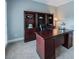 Traditional office space with a rich wood desk, built-in shelving, and plush carpeting for a comfortable workspace at 200 Long Needle Ct, Sugar Hill, GA 30518