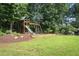 Backyard playground with a swing set and slide, nestled among mature trees at 200 Long Needle Ct, Sugar Hill, GA 30518