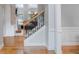 Elegant staircase with wrought iron railings and hardwood floors leading to the upper level at 200 Long Needle Ct, Sugar Hill, GA 30518
