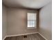 A neutrally decorated bedroom features new wood flooring and a window providing natural light at 3637 Chinaberry Ln, Snellville, GA 30039