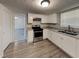Bright kitchen with white cabinets, gray countertops, stainless steel appliances and vinyl plank flooring at 3637 Chinaberry Ln, Snellville, GA 30039