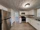 Kitchen with stainless steel appliances, gray countertops and white cabinets at 3637 Chinaberry Ln, Snellville, GA 30039