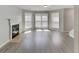 Bright and airy living room featuring a fireplace, three large windows and light vinyl plank flooring at 3637 Chinaberry Ln, Snellville, GA 30039