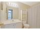 Well-lit bathroom features a white cabinet, a toilet, and shower behind a striped curtain at 375 Shadetree Ln, Lawrenceville, GA 30044