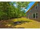 Backyard with lush green grass, mulch rings around the trees, and a two-story house at 3876 Thackary Dr, Powder Springs, GA 30127