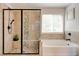 Modern bathroom featuring a glass-enclosed shower and a soaking tub at 3876 Thackary Dr, Powder Springs, GA 30127