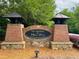The Meadow at Miller's Pond community entrance featuring brick columns and a decorative sign with lush greenery in the background at 3876 Thackary Dr, Powder Springs, GA 30127