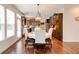 Elegant dining area with wood floors, a chandelier, natural light, and an open layout to the kitchen at 3876 Thackary Dr, Powder Springs, GA 30127