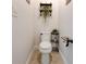 Small half bathroom featuring a toilet, decorative shelves, and minimal decor at 3876 Thackary Dr, Powder Springs, GA 30127