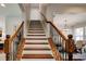 Elegant staircase with wooden rails and iron balusters, leading to the upper level of the home at 3876 Thackary Dr, Powder Springs, GA 30127