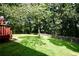 Spacious backyard featuring a well-maintained lawn, mature trees, and a wooden fence at 5040 Puritan Dr, Sugar Hill, GA 30518