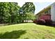 Expansive backyard featuring a well-manicured lawn, lush trees, and a deck area at 5040 Puritan Dr, Sugar Hill, GA 30518