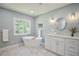Bright bathroom featuring a soaking tub, double vanity, and large window at 5040 Puritan Dr, Sugar Hill, GA 30518