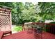 Relaxing outdoor deck setting with glass table and chairs surrounded by lush greenery at 5040 Puritan Dr, Sugar Hill, GA 30518