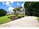 View of this beautiful home featuring manicured landscaping, a winding driveway, and a peek at the home's side entry garage at 5040 Puritan Dr, Sugar Hill, GA 30518