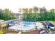 Aerial view showcasing a luxurious community pool area with cabanas, lounge chairs, and a playground at 566 Silver Moon Dr, Loganville, GA 30052
