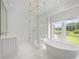 Bright bathroom featuring a soaking tub, separate glass shower, and outdoor views at 1640 Kenai Rd, Kennesaw, GA 30152