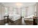 Bright bedroom with hardwood floors, decorative chandelier, and access to outdoor views at 1640 Kenai Rd, Kennesaw, GA 30152