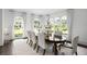 Elegant dining room with large windows, white chairs, and a dark wood table at 1640 Kenai Rd, Kennesaw, GA 30152