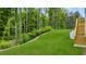 A lush backyard with stairs leading to a deck, and surrounded by mature trees at 51 Black Rock Rdg, Sharpsburg, GA 30277
