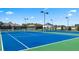 Community tennis courts with green and blue surface, surrounded by fence and light posts at 575 Silver Moon Dr, Loganville, GA 30052