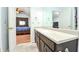 Bright bathroom featuring a large vanity with double sinks, view to the bedroom, and a walk-in closet at 737 Wilkes Dr, Loganville, GA 30052