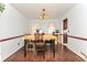 Cozy dining room featuring a classic chandelier, neutral wall color, and dark wood floors and table at 737 Wilkes Dr, Loganville, GA 30052