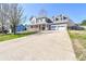 A gray two story house with a large driveway and a two car garage, featuring a welcoming front porch at 737 Wilkes Dr, Loganville, GA 30052