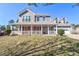 Charming two-story home featuring a welcoming front porch, gray siding, and a well-maintained lawn on a sunny day at 737 Wilkes Dr, Loganville, GA 30052