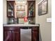 Wet bar with dark wood cabinets, shelving, and a stainless steel refrigerator provides convenient entertaining at 2508 Haddenham Sw Ln, Smyrna, GA 30082
