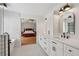 Bright bathroom featuring a white double vanity, modern fixtures, and a soaking tub with views into the main bedroom at 2508 Haddenham Sw Ln, Smyrna, GA 30082